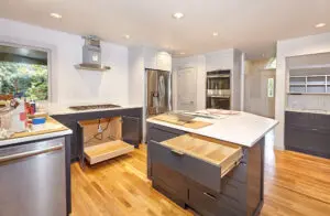 Modern kitchen with wooden floors, dark cabinets, stainless steel appliances