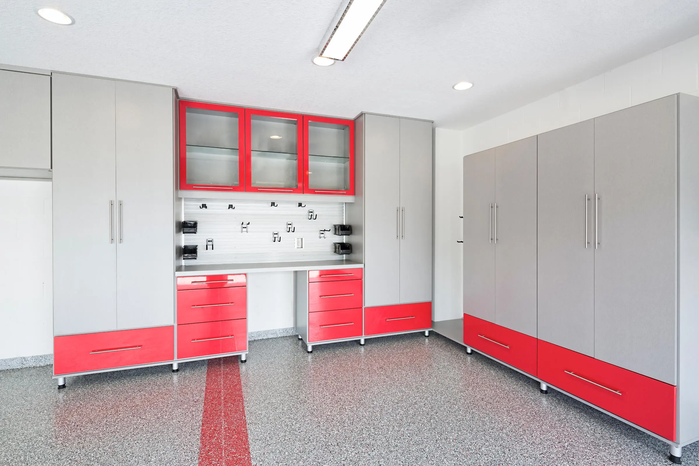 Modern kitchen with red and gray cabinets and a patterned backsplash in a bright