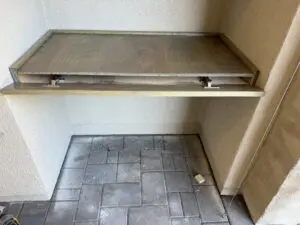Foldable wall mounted table on tiled patio.