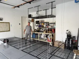 Man installing overhead storage in garage.