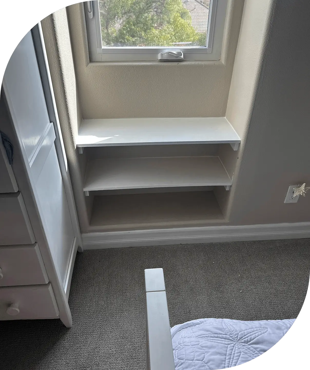 White shelves below window in room corner.